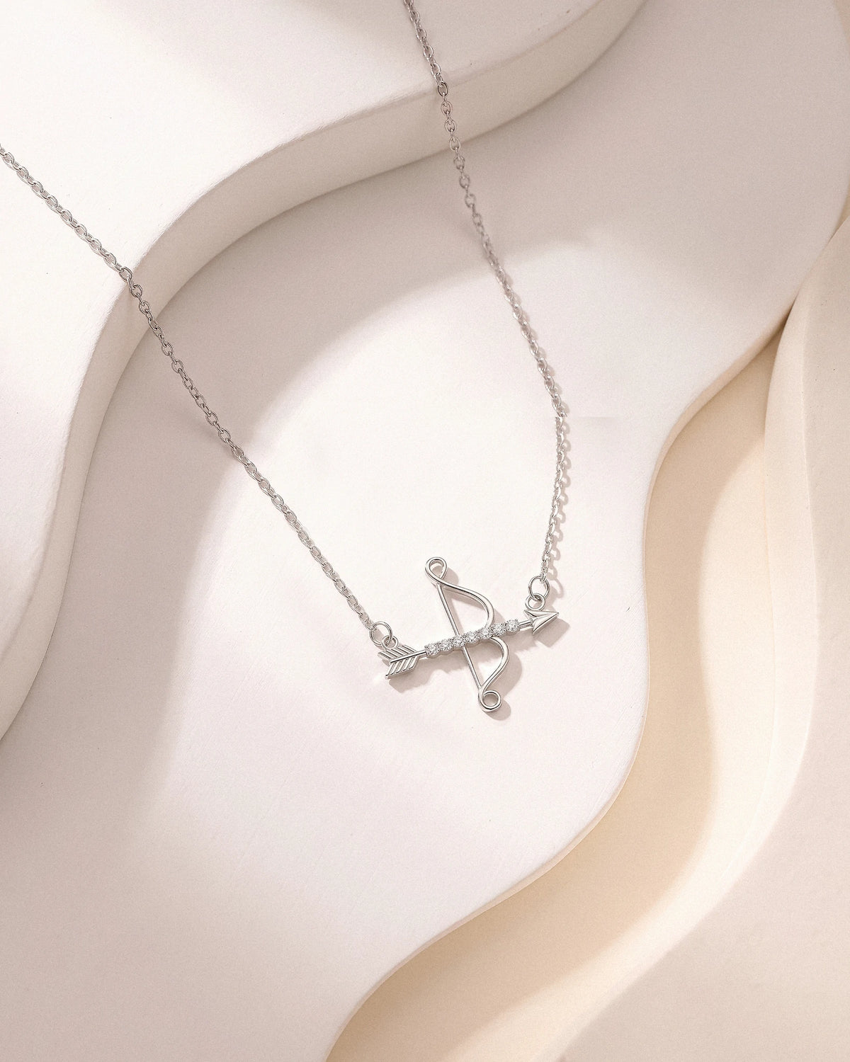 The Archer necklace worn, pendant close-up